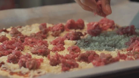 Medium close up finishes spreading fresh minced meat as a pizza topping Stock Footage 127969819