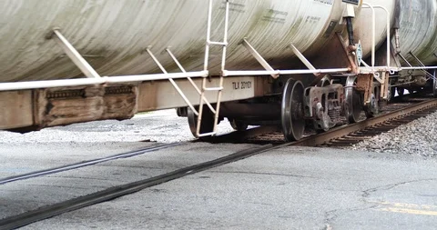 Medium close up, freight train under carriage, wheel assembly entering crossing Stock Footage 117937642