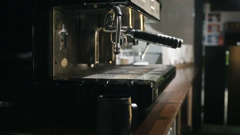 Medium close up of hand holding cup with milk under the steam of coffee machine Stock Footage 127587044
