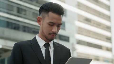 Medium close up. Handsome young asian businessman working on laptop Stock Footage 138908447