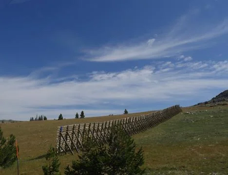 Medium close up of a hillside view with a high wooden fence on a beautiful day  Stock Photos