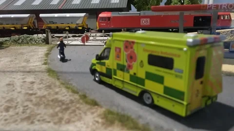 Medium Close Up of Hornby Train Model Passing Level Crossing Petrol Station Stock Footage 284260282