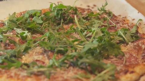 Medium close up a man chef cutting a home made salad salad pizza using a sontoku Stock Footage 127986884