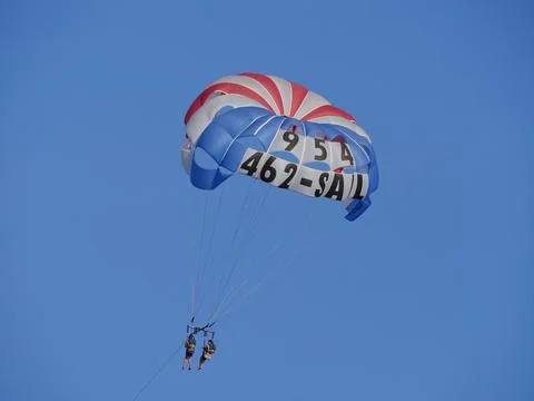 Medium close up of a red, white and blue parasail floating in the air.  写真素材