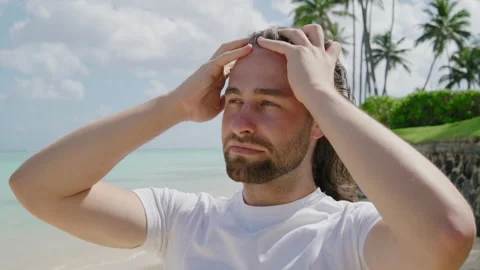 Medium close up of sexy man with long-haired and beard on tropical beach, Oahu Stock Footage 267329913