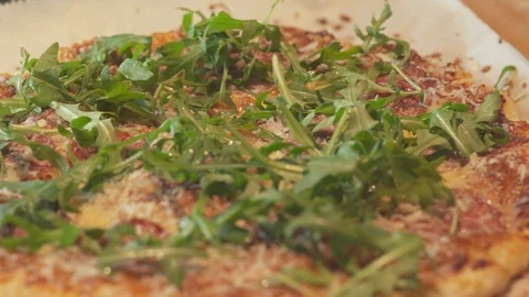 Medium close up shadow of a man chef cracking a salt and pepper top salad pizza Stock Footage 127986545