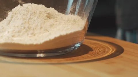 Medium close up shot adding salt to a wheat flour for baking in mixing bowl Stock Footage 127954068