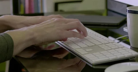Medium close shot of female hands typing with ipad and mug in shot Stock Footage 68446994