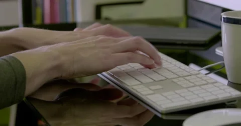 Medium close shot of female hands typing and using mouse with ipad and mug. Stock Footage 68447416