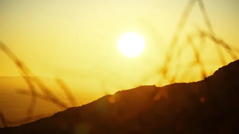 A medium close shot of the golden sunset behind the mountain top Video stock 282009740