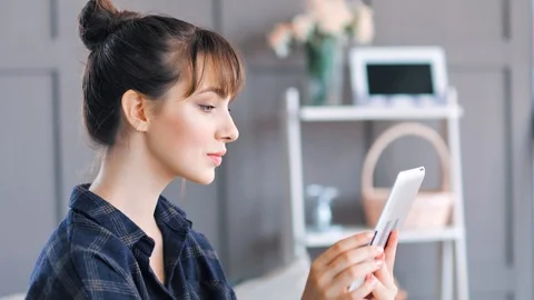Medium close-up shot household nice young woman writing text message using Stock Footage 93398221
