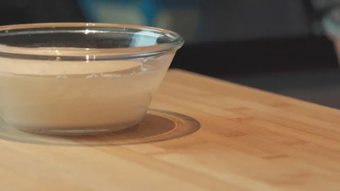 Medium close up shot mixing yeast into wheat flour for pizza bread dough Stock Footage 127954994