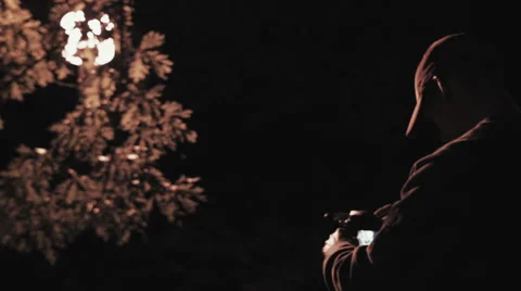 Medium Close up shot of photographer using camera at night Stock Footage 60269018