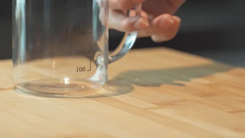 Medium close up shot pouring water into pyrex or measurement glass metric system Stock Footage 127952557