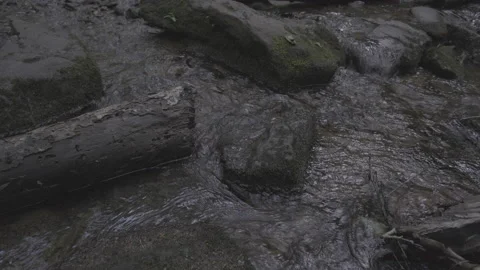 Medium close shot of water flowing around rocks in a creek. Video stock 133086430