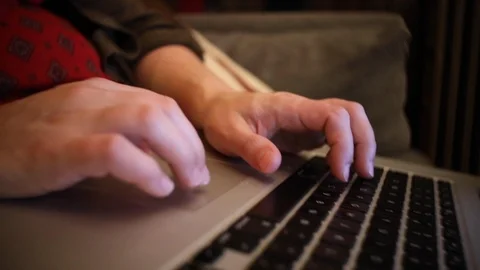 A medium close up shot of a woman's hands on a laptop track pad and keyboard Stock Footage 103602533
