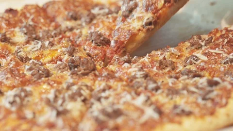Medium close up showing a slice of a minced meat fresh pizza freshly baked Stock Footage 127972267