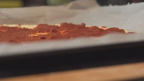 Medium close up shredding mozzarella chesse on pizza dough tomato paste Stock Footage 127969019