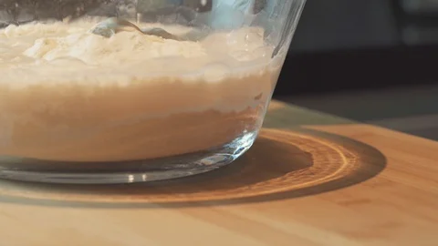 Medium close up start mixing yeast wheat in a large mixing bowl using spatula Stock Footage 127955620