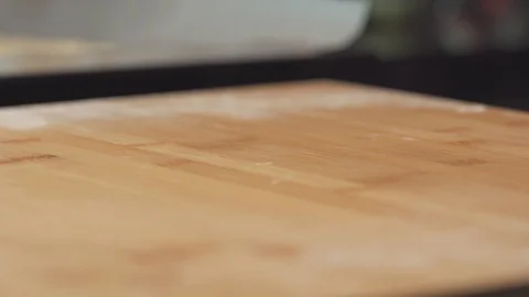 Medium close up start to spread a tomato paste sauce onto a pizza bread dough Stock Footage 127967805