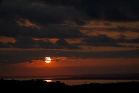 Medium close up of the sun setting over a river mouth in South Wales UK Stock Photos
