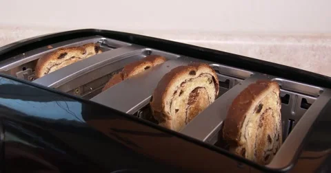 Medium close up of toast in a toaster, going down and popping up, in 4K Stock Footage 57625937