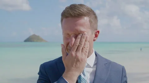 Medium close up of a young man in a suit and tie standing on beach, Hawaii, Oahu Stock Footage 265484409