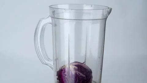 Medium closes up slow motion, purple cabbages fall into a blender. Видео 137769444