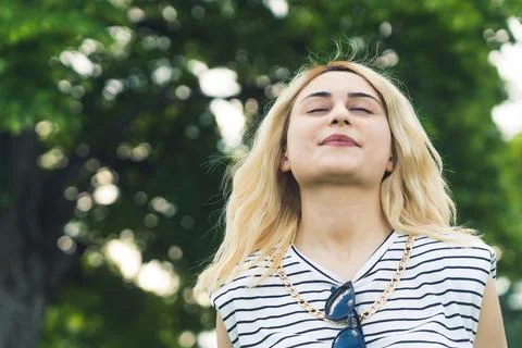 Medium closeup shot of a young blond Caucasian girl enjoying the fresh air in Stock Photos