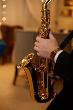 Medium closeup of unrecognizable Black jazz musician playing saxophone on stage Stock Photos