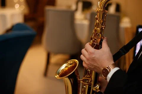 Medium closeup of unrecognizable Black jazz musician playing saxophone on stage Stock Photos
