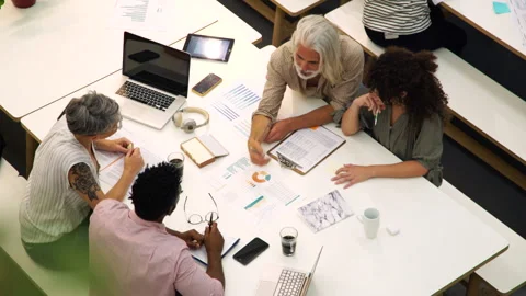 Medium elevated shot of group of coworkers sitting in shared open workspace Stock Footage 277956417