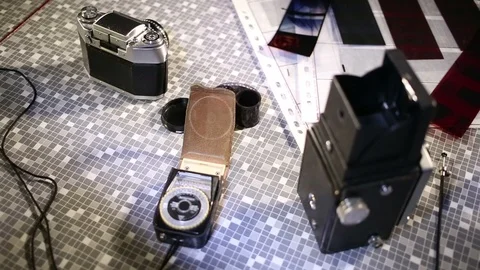 Medium format camera, film strips and contact sheet on table. Video stock 85977026