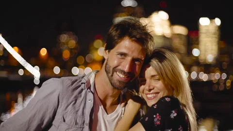 Medium front view shot of cheerful young couple looking at camera while enjoying Stock Footage 277971453