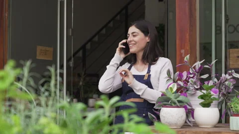 Medium front view shot of female small business owner speaking on mobile phone Stock Footage 277962609