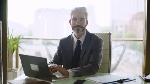 Medium front view shot of middle aged lwayer looking up from his computer screen Stock Footage 277972033