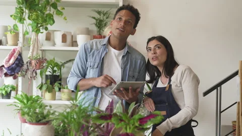Medium front view shot of two diverse small business owners checking inventory Stock Footage 277963190