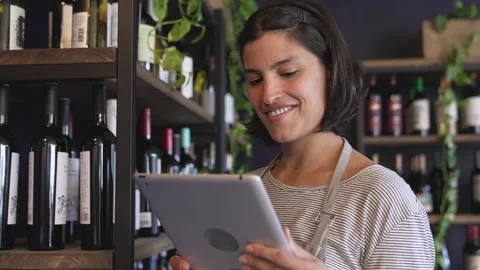 Medium front view shot of young female entrepreneur checking her wine inventory Stock Footage 277963867