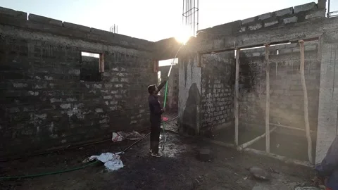 Medium full length view documenting a male construction builder spraying water Stock Footage 337869619