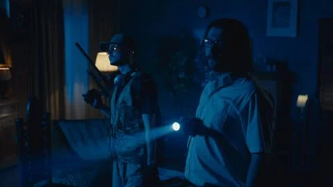 Medium-full photo capturing two ghost hunters entering a dark room in search for 写真素材