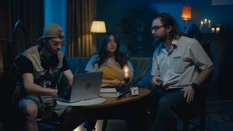 Medium-full photo capturing two ghost hunters and a victim sitting at the table 스톡 사진