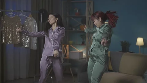 Medium-full video capturing two young women having fun, dancing in a room 動画素材 252220082