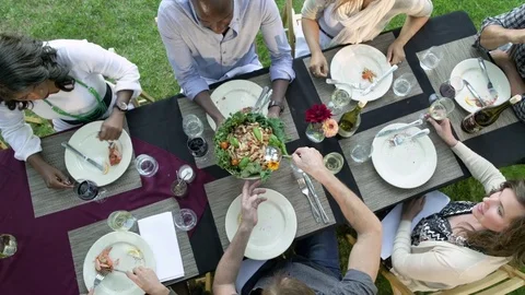 Medium group of people having an outdoor dinner party Stock Footage 77083360
