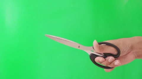 Medium hand gesture using large scissors on a green background. Vidéo 305685153