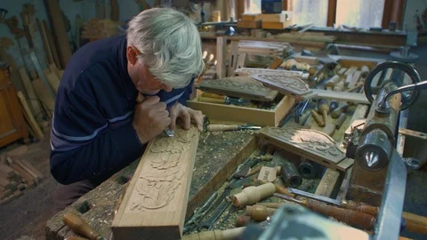 Medium hand-held shot of wood carver who is carving an oak plank. Stock Footage 103604468