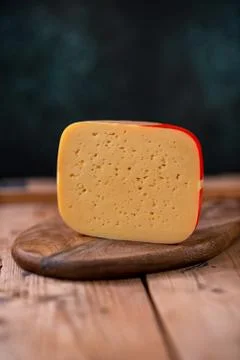 Medium hard cheese gouda edam on wooden board on sunlight table traditional t Stock Photos