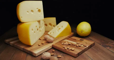 Medium hard cheese head edam gouda parmesan on wooden board, with nuts and honey Video stock 146783754