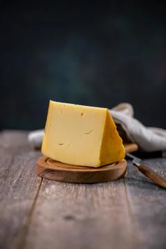 Medium hard cheese head edam gouda parmesan on wooden board with knife wooden Stock-Fotos