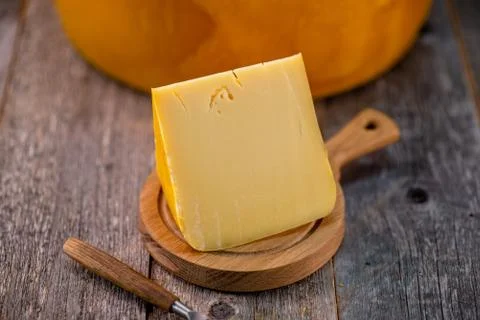 Medium hard cheese head edam gouda parmesan on wooden board with knife wooden Foto stock