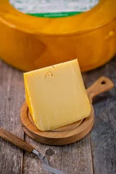 Medium hard cheese head edam gouda parmesan on wooden board with knife wooden Stock-Fotos